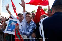 Image du Maroc Professionnelle de  Les habitants de Laayoune agitent leur drapeau national dans les rues de la ville durant la visite du Roi Mohammed VI du Maroc qui entame une campagne pour promouvoir le plan de décentralisation marocain et stimuler les investissements à Laayoune, samedi 7 novembre 2015. Le Roi Mohammed VI effectue sa première visite officielle au Sahara depuis 2006, à l'occasion du 40e anniversaire de la Marche verte, son père, le défunt roi Hassan II, avait envoyé 350 000 Marocains sans armes pour recouvrir l'intégrité territoriale du Maroc. (Photo / Abdeljalil Bounhar) 